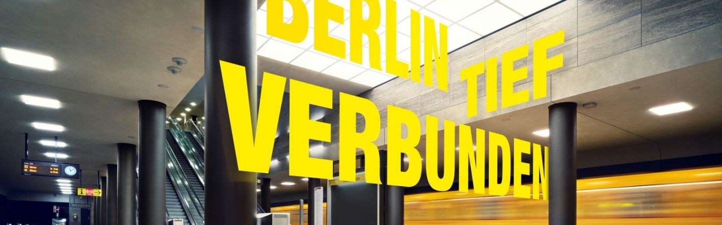 Eine U-Bahn fährt durch den neuen U-Bahnhof Unter den Linden. Darüber wird das Motto der neuen U5 "Berlin tief verbunden" eingeblendet.